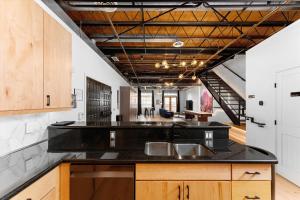 a kitchen with a black counter top and wooden cabinets at Hotel Residential of Denver in Denver