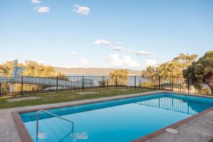 a swimming pool with a view of the water at Reflections Lake Burrendong - Holiday Park in Mumbil