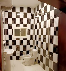 a bathroom with a black and white checkered wall at سرر المحمديه البطحاء in Riyadh