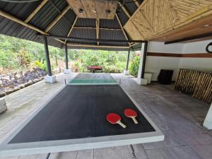 una mesa de ping pong con dos paletas rojas. en Camping La Penal, en Cumandá