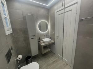 bagno con lavandino, servizi igienici e specchio di Playera bungalow F sea view a Kolympithres