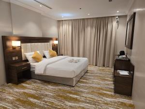 una camera d'albergo con letto e finestra di سحابة الأحلام - Dream Cloud Hotel a Gedda