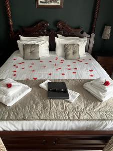 ein Bett mit roten Rosen und einem Laptop darauf in der Unterkunft The George Inn in Hatherleigh