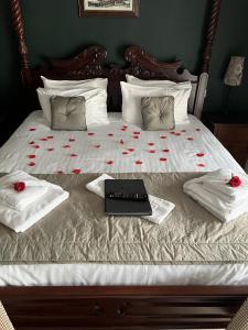 a bed with red roses and a laptop on it at The George Inn in Hatherleigh