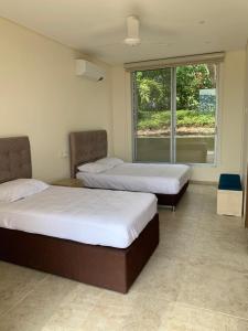 um quarto com 2 camas e uma grande janela em Exclusiva y Moderna Casa Campestre em Anapoima