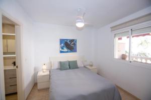 ein weißes Schlafzimmer mit einem Bett und einem Fenster in der Unterkunft ESPECTACULAR PISO EN LA HERRADURA, con parking gratis en julio y agosto in La Herradura