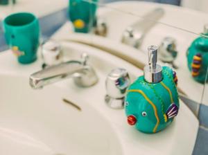 a bathroom sink with a green soap dispenser on it at Casa Silvana, Capri - Relaxando en el verde in Capri +56 photos
