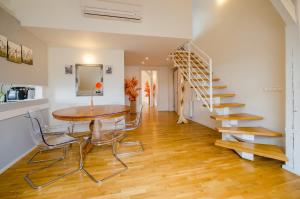 a dining room with a table and a spiral staircase at Historic Centre Apartments I in Prague