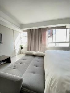 un grande letto in una camera da letto con una grande finestra di WINK Hotel- Next to CTICC & Best Tourist Location a Città del Capo