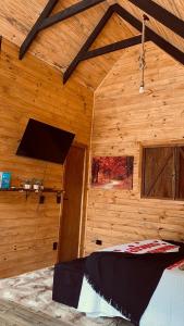 a room with a bed in a wooden cabin at chalé Platanus in Campos do Jordão