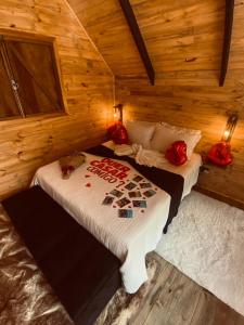 um quarto com uma cama num chalé de madeira em chalé Platanus em Campos de Jordão