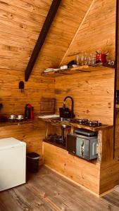 a kitchen with a stove in a wooden cabin at chalé Platanus in Campos do Jordão