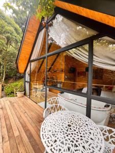 a balcony of a house with a table and a window at chalé Platanus in Campos do Jordão