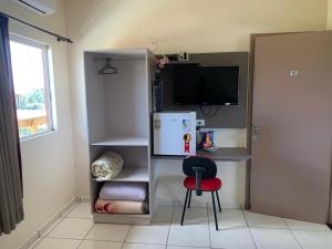 Zimmer mit einem Kühlschrank, einem Stuhl und einem Schreibtisch. in der Unterkunft Hotel Goedert 