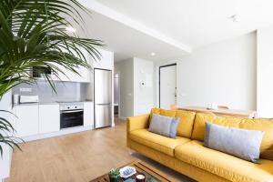 AbadesにあるAbades Holiday Homeのリビングルーム(黄色のソファ付)、キッチンが備わります。