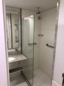 een badkamer met een glazen douche en een wastafel bij Flat Granja Brasil Resort in Petrópolis