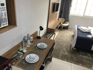 een kleine kamer met een tafel en een bed bij Flat Granja Brasil Resort in Petrópolis