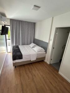 a bedroom with a bed in a room with wooden floors at Hotel do Vale in Campina Grande