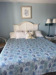 een slaapkamer met een groot bed en een blauw dekbed bij Oceanview Efficiency DW1510 in Myrtle Beach