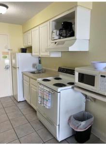 een keuken met een wit fornuis en een magnetron bij Oceanview Efficiency DW1510 in Myrtle Beach