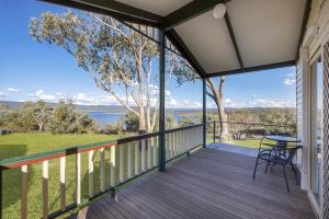 a balcony with a table and chairs and a view of the water at Reflections Lake Burrendong - Holiday Park in Mumbil