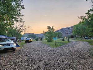 a gravel road with cars parked on the side at #5 Cabin Fever in Drumheller