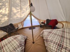 um quarto com uma tenda com 2 cadeiras e uma janela em #5 Cabin Fever em Drumheller