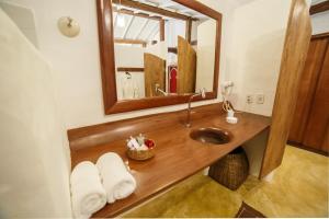 a bathroom with a wooden sink and a mirror at Pousada El Gordo in Trancoso