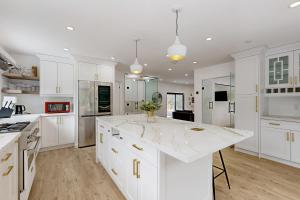 a kitchen with white cabinets and a white counter top at Rolling River Retreat in Midhurst