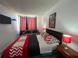 a bedroom with a bed and a table with a lamp at Apartment Relocation San Isidro in Santiago