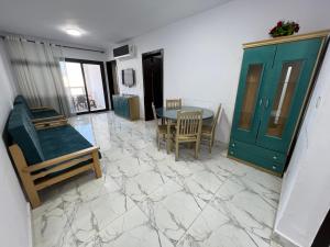 a room with a table and chairs and a green door at بورسعيد - بورتوسعيد شاليه فندقى 3 غرف Porto Said Rental in `Ezbet Shalabi el-Rûdi