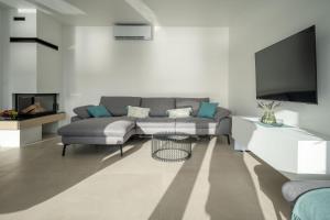 a living room with a couch and a tv at Villa Laganini in Rogoznica