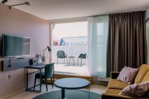 a living room with a couch and a table and a window at Scandic Rubinen in Gothenburg