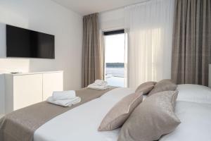 a bedroom with a large bed with a large window at Villa Laganini in Rogoznica +24 photos