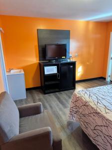 a hotel room with a bed and a flat screen tv at Budget Inn Decatur Priceville in Decatur +10 photos
