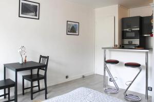 een woonkamer met een tafel met een magnetron en stoelen bij Nice studio close to Paris in Montrouge