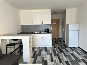 eine kleine Küche mit weißen Schränken und einem Kühlschrank in der Unterkunft Zentrumsnahe 1-Zimmer-Wohnung in Karlsruhe