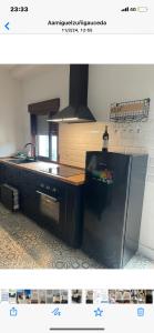 a kitchen with a black refrigerator and a sink at Río Genil in Pinos Genil