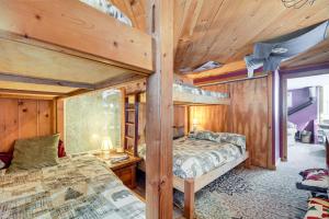 two bunk beds in a room with wooden walls at Waitsfield Home with Hot Tub - Close to Sugarbush! in Waitsfield