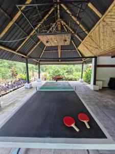 una mesa de ping pong con dos setas rojas. en La Penal Amazon Lodge!, en Mera