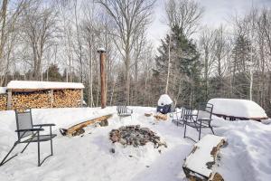 a snow covered yard with chairs and a fire pit at Waitsfield Home with Hot Tub - Close to Sugarbush! in Waitsfield