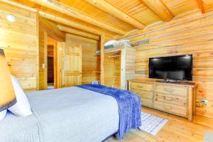 a bedroom with a bed and a flat screen tv at Cozy Mountain Condo Across From Snow King Ski Mtn! in Jackson