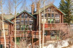 a log cabin with a wrap around deck at Cozy Mountain Condo Across From Snow King Ski Mtn! in Jackson