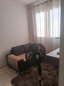 a room with a fan in front of a couch at Espaçossego 83 oito meia 82 vinte 74 in Campina Grande