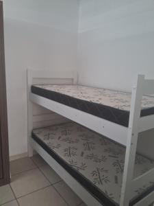 a white bunk bed with a black and white mattress at Espaçossego Tv na sala e no quarto e Netflix in Campina Grande
