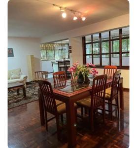 a dining room table with chairs and flowers on it at Amplio Apto al este de Caracas in Caracas