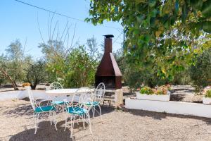 una mesa y sillas y una chimenea en un patio en Mas Xanxo en Riudoms