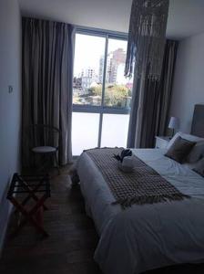 ein Schlafzimmer mit einem Bett und einem großen Fenster in der Unterkunft Barrancas de Madero in Buenos Aires