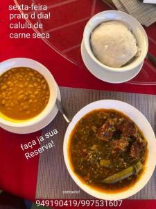 a table with a bowl of food and a bowl of soup at Hospedaria Restaurante Xeque Mate in Luanda