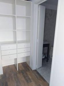 a white closet with white shelves and a table at Barrancas de Madero in Buenos Aires